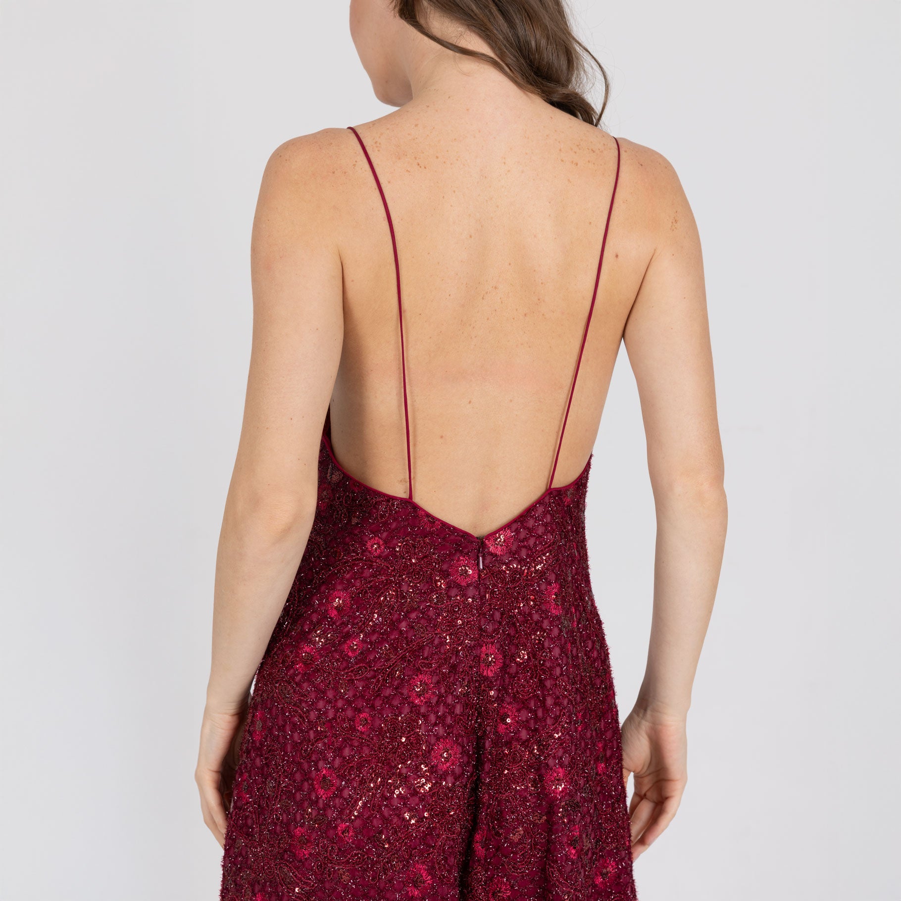 Detail of deep V open back and embroidery on Vedra red gown – luxury eveningwear