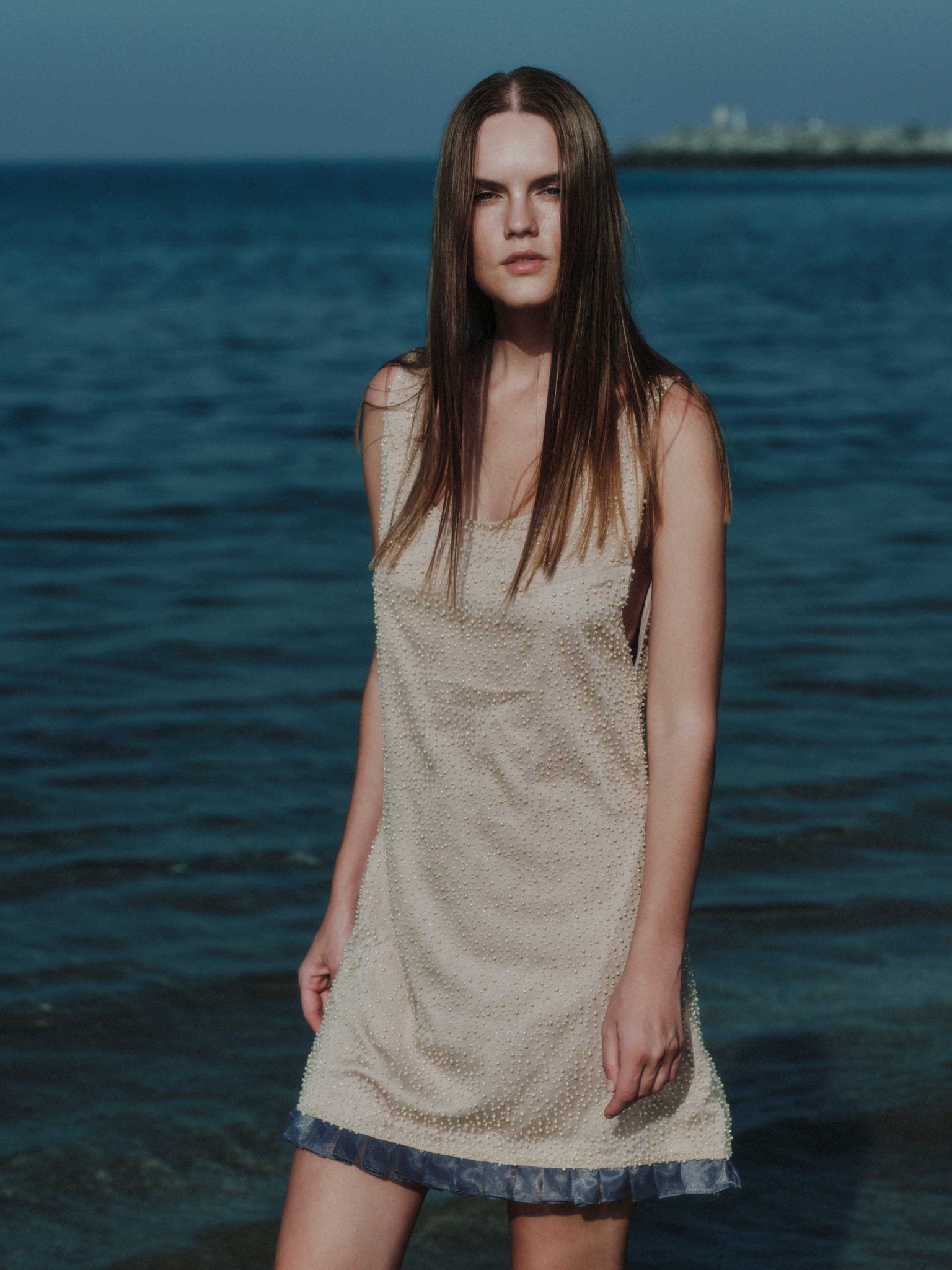 Side view of Aurea luxury mini dress with pleated hem