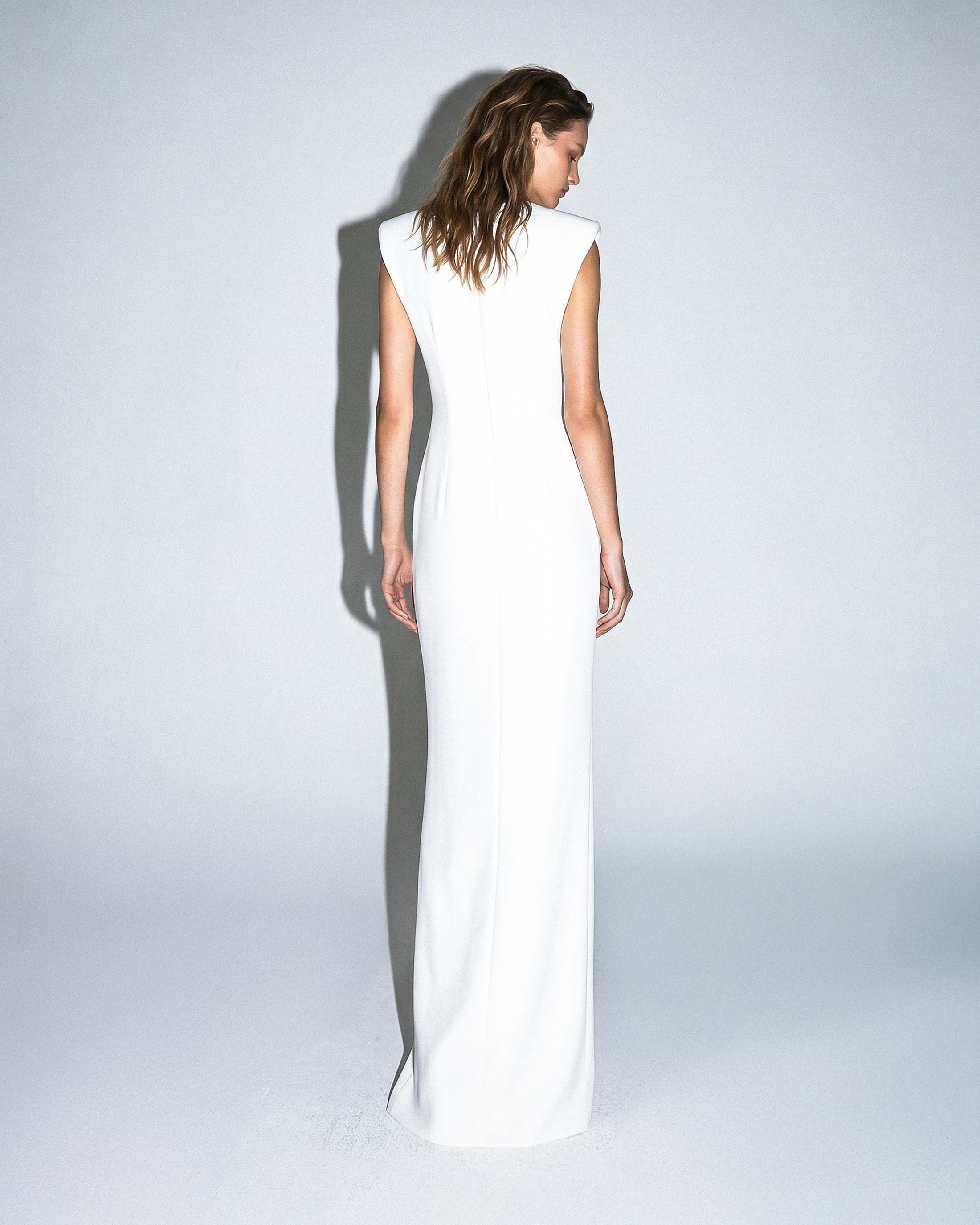 Back view of ISARA white floor-length gown with clean minimalist design