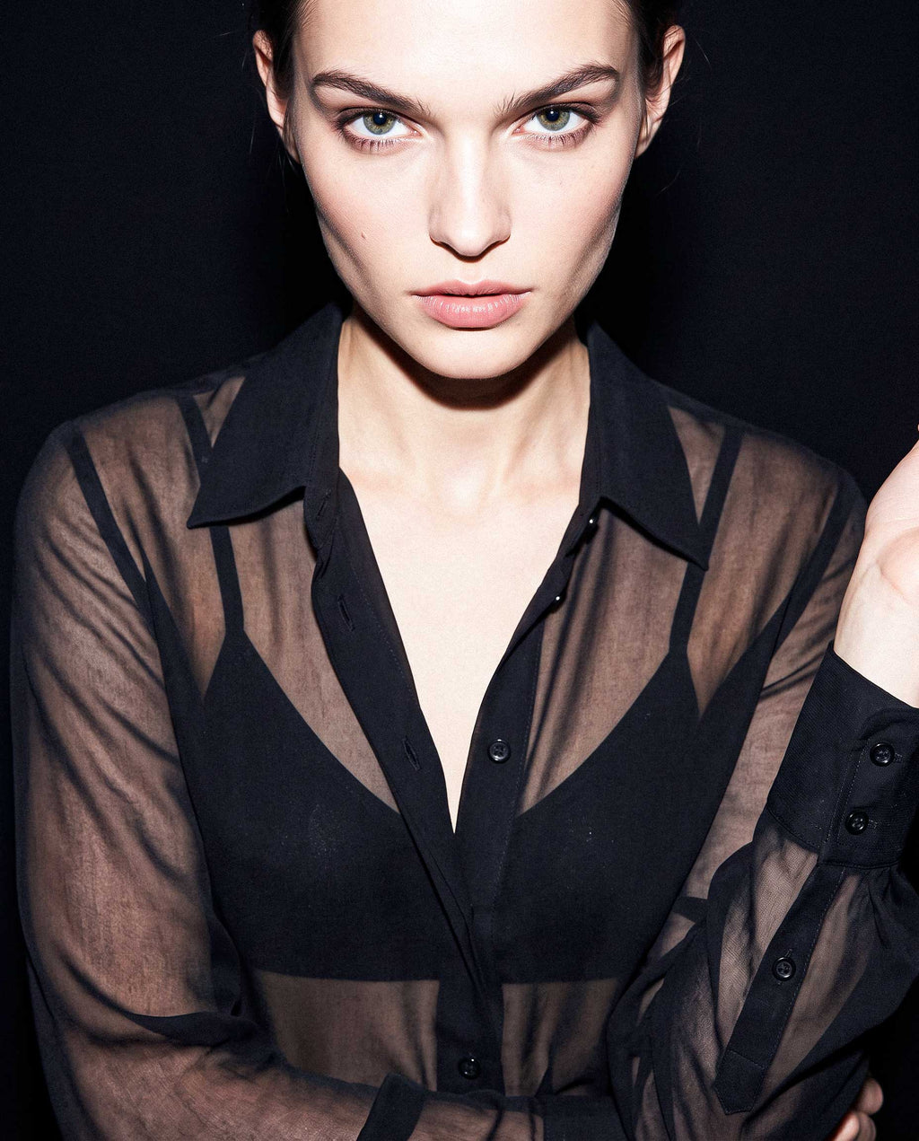 Portrait detail of a black sheer silk chiffon shirt with pointed collar, transparent texture and layered black styling by A|LOUD
