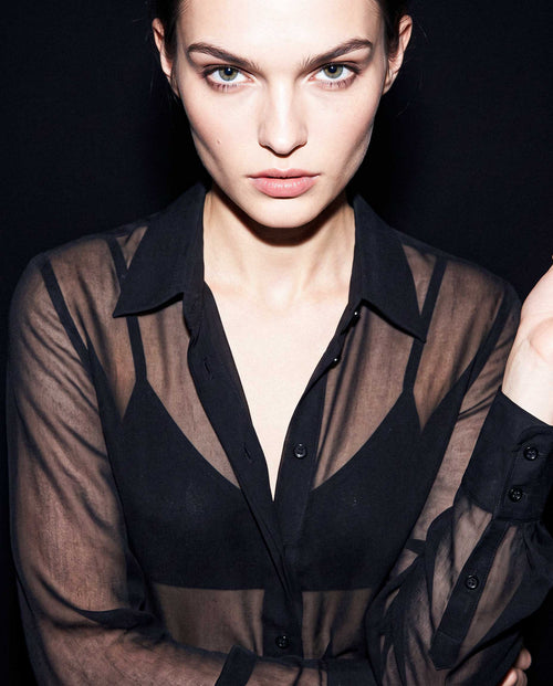 Portrait detail of a black sheer silk chiffon shirt with pointed collar, transparent texture and layered black styling by A|LOUD