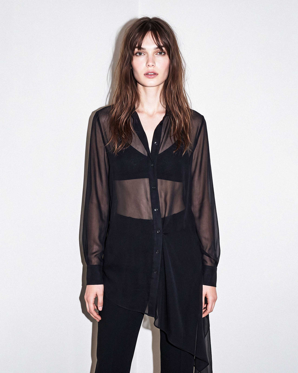 Front view of the black sheer silk chiffon shirt styled with black tailored crepe trousers by A|LOUD