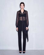 Full front look of the black sheer silk chiffon shirt paired with black tailored crepe trousers by A|LOUD