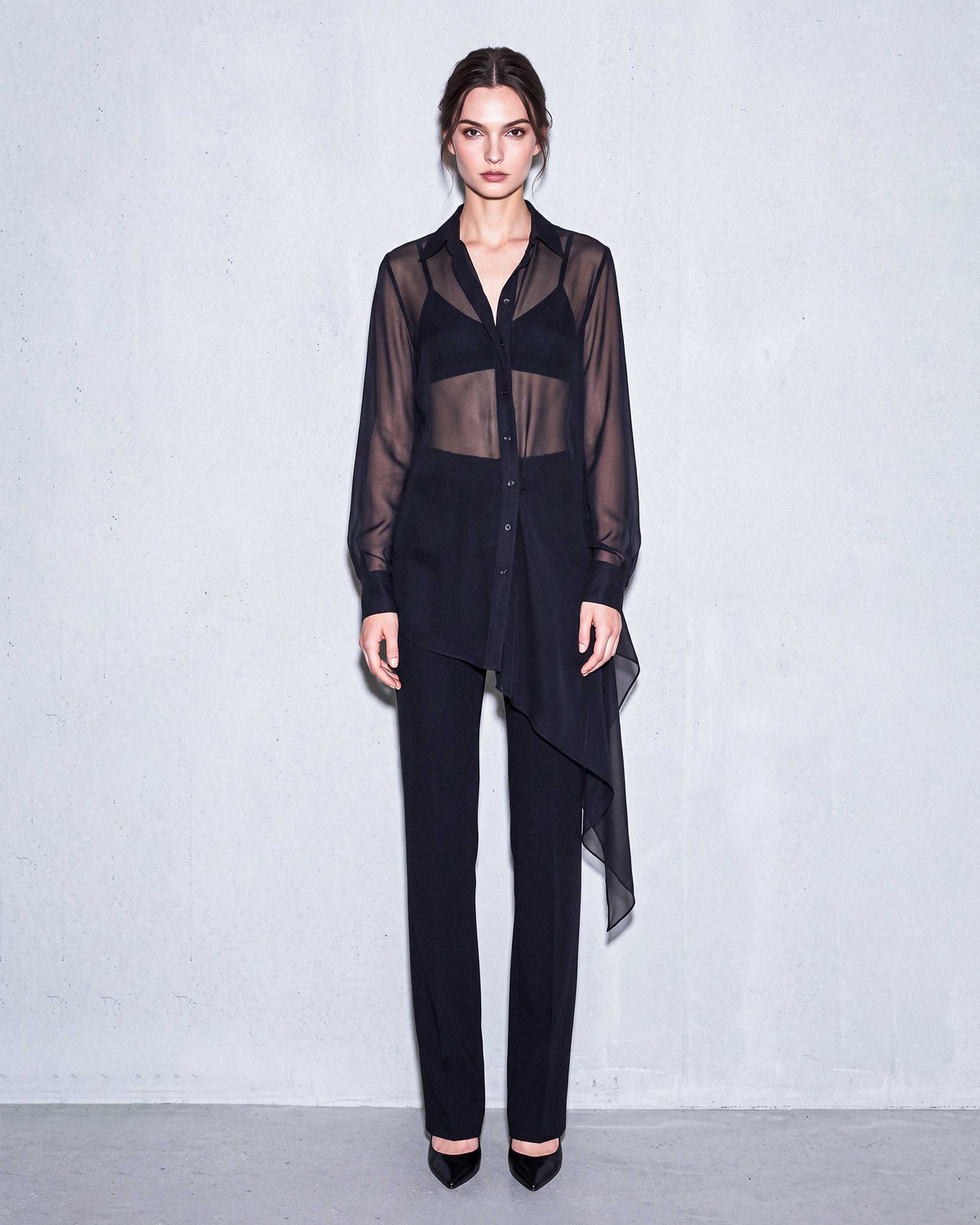 Full front look of the black sheer silk chiffon shirt paired with black tailored crepe trousers by A|LOUD