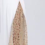 Detail of gold lace panel on white satin dress – refined couture embellishment