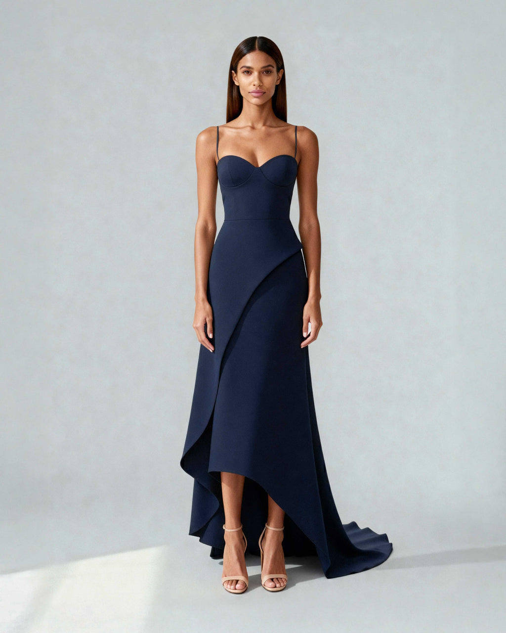 Model wearing navy blue crepe gown with sweetheart neckline and asymmetric front panel