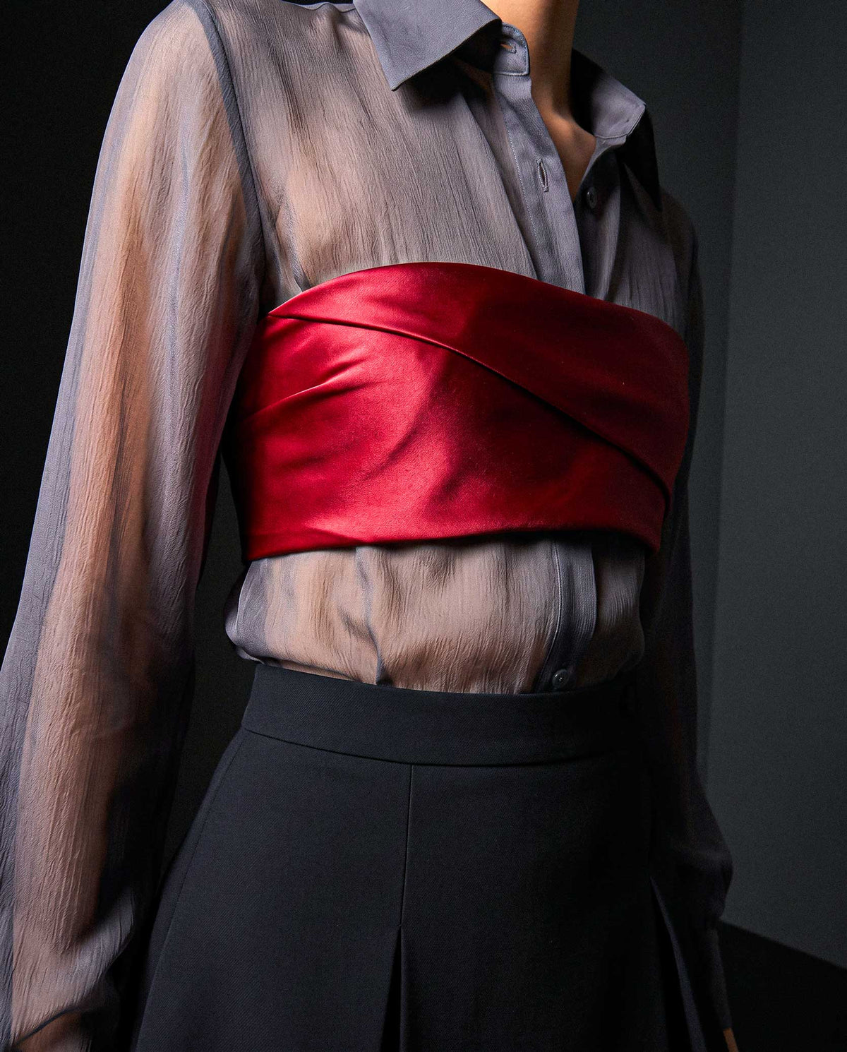 Side detail of the ÉLYR burgundy silk satin bandeau showing the sculptural satin wrap over a sheer charcoal silk chiffon shirt by A|LOUD