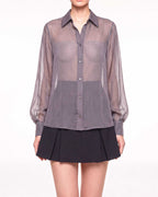 Front detail of the ÉLYR sheer charcoal silk chiffon shirt with button closure, pointed collar and voluminous sleeves by A|LOUD
