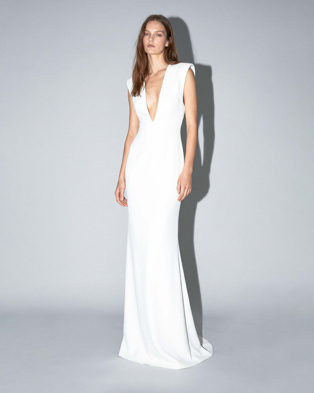 ISARA white evening gown with deep V neckline and sculpted shoulders
