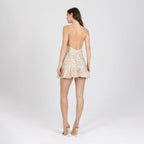 Back view of gold lace mini dress with low V open back and rouleau straps