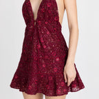 Red embroidery detail on structured mini dress – couture-inspired craftsmanship