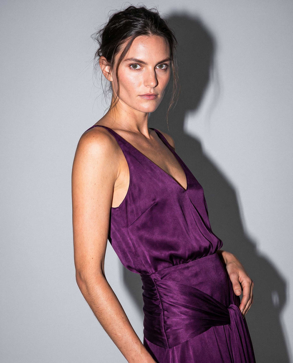 Close-up of purple satin evening dress with soft draping and elegant neckline