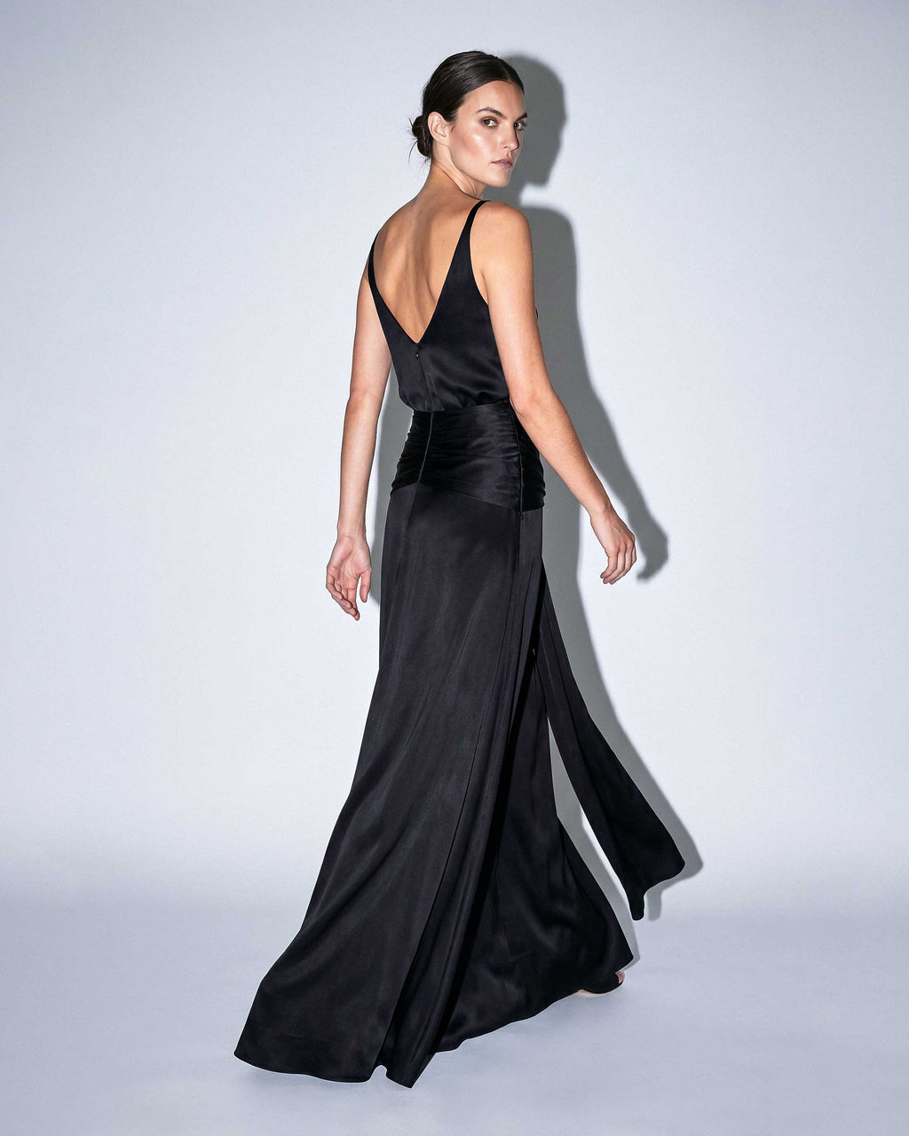 Open-back black satin evening gown with fitted waist and fluid skirt