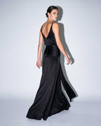 Open-back black satin evening gown with fitted waist and fluid skirt