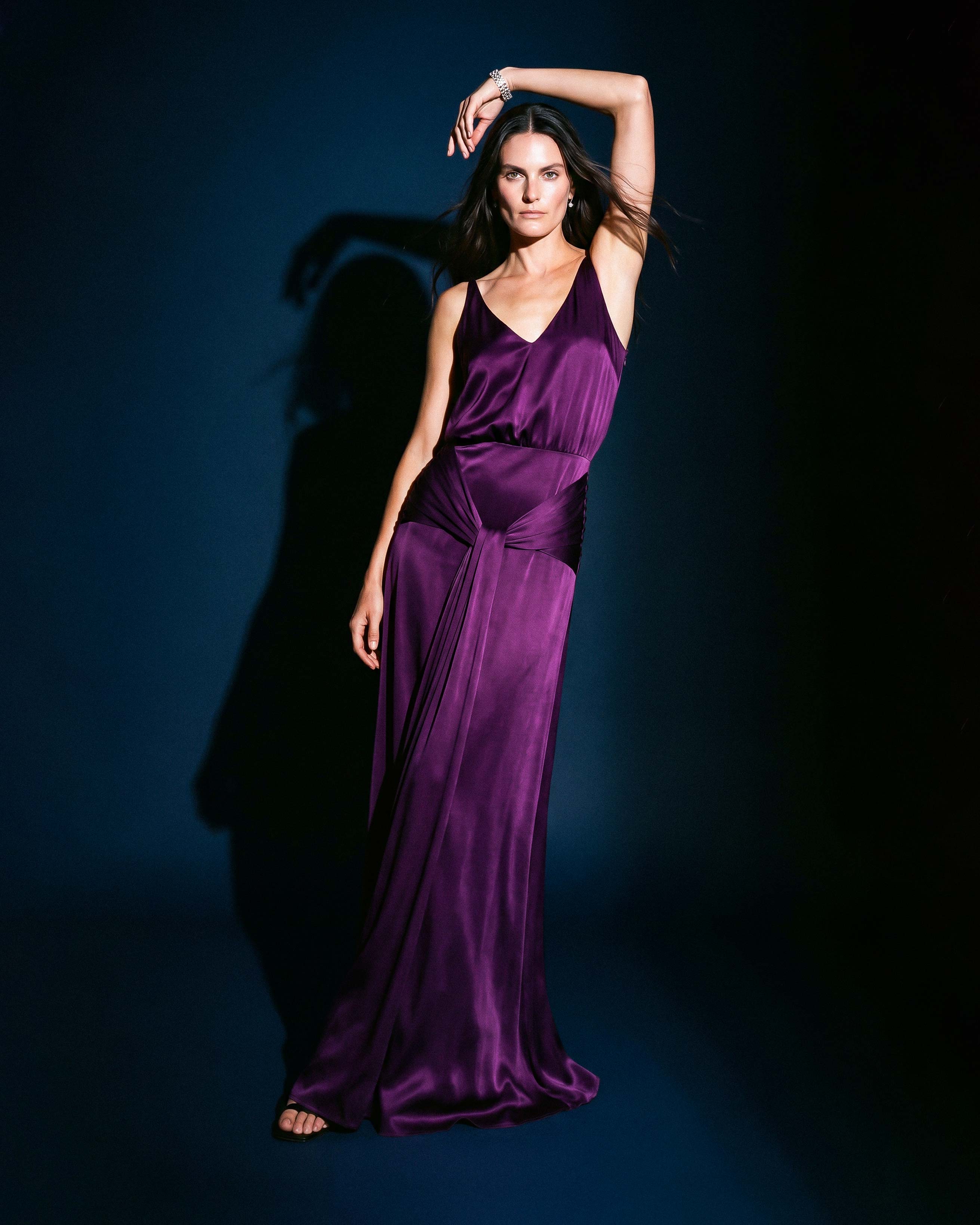 Purple satin evening dress with deep neckline and fluid full-length silhouette