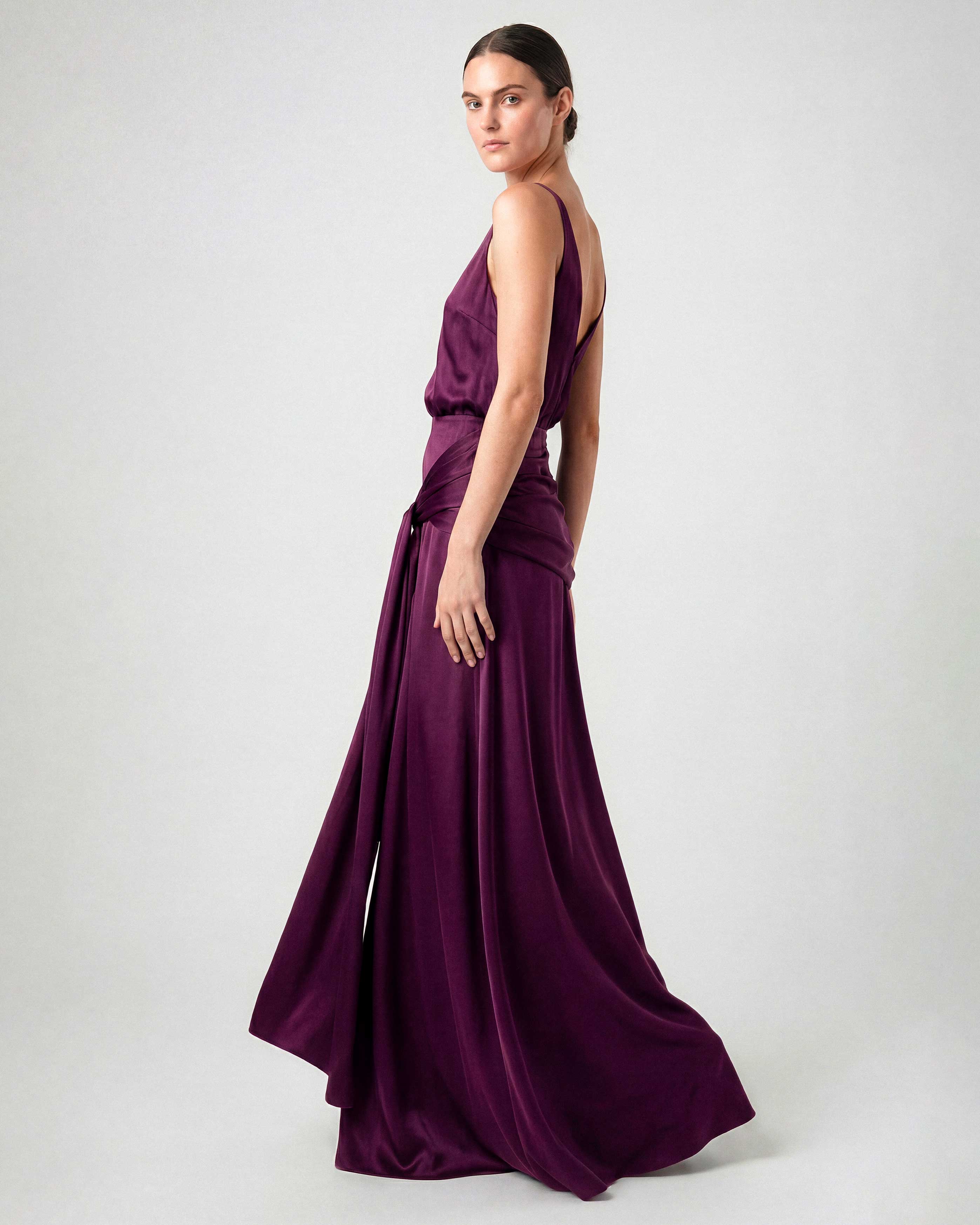 Side view of burgundy satin evening dress with fluid silhouette
