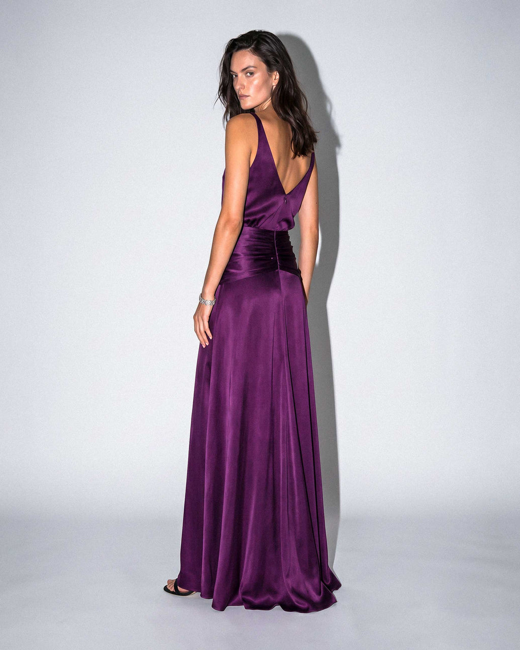 Purple satin evening gown captured in motion with fluid skirt and open back