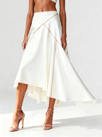 Side view of white crepe midi skirt with curved satin piping, captured mid-motion to reveal layered hem.