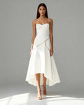 Model wearing Nayla white midi dress with gold piping, sweetheart neckline and asymmetrical hem