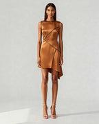 Model wearing copper satin mini dress with navy piping and asymmetric hem – front view