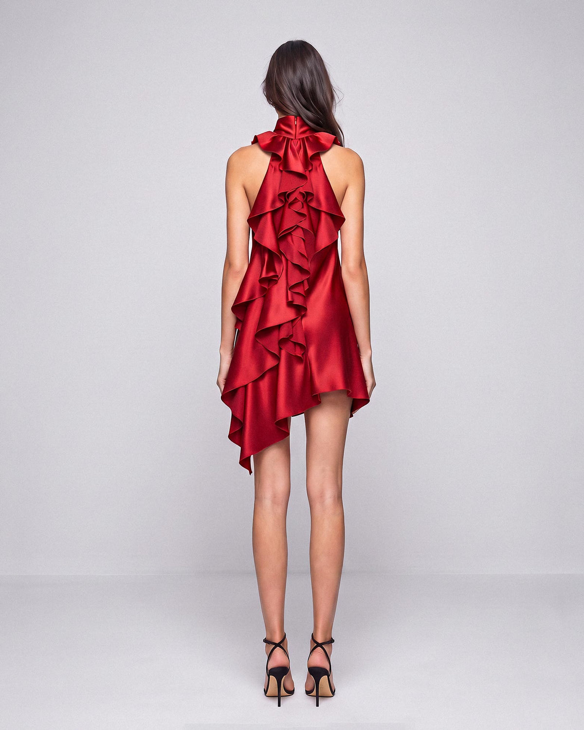 Full back view of the red silk satin mini dress showing the cascading back ruffles and asymmetric hem by A|LOUD.