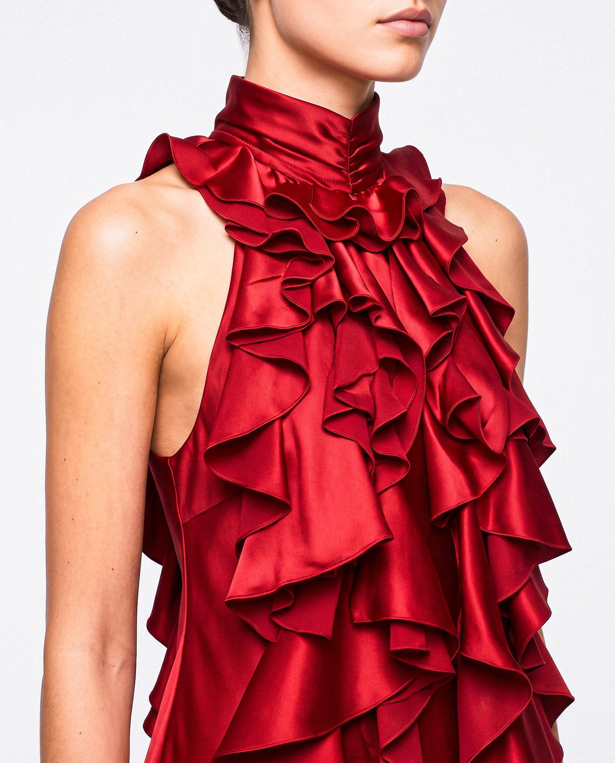 Close-up of the high neckline and cascading ruffle construction of the red silk satin mini dress by A|LOUD.