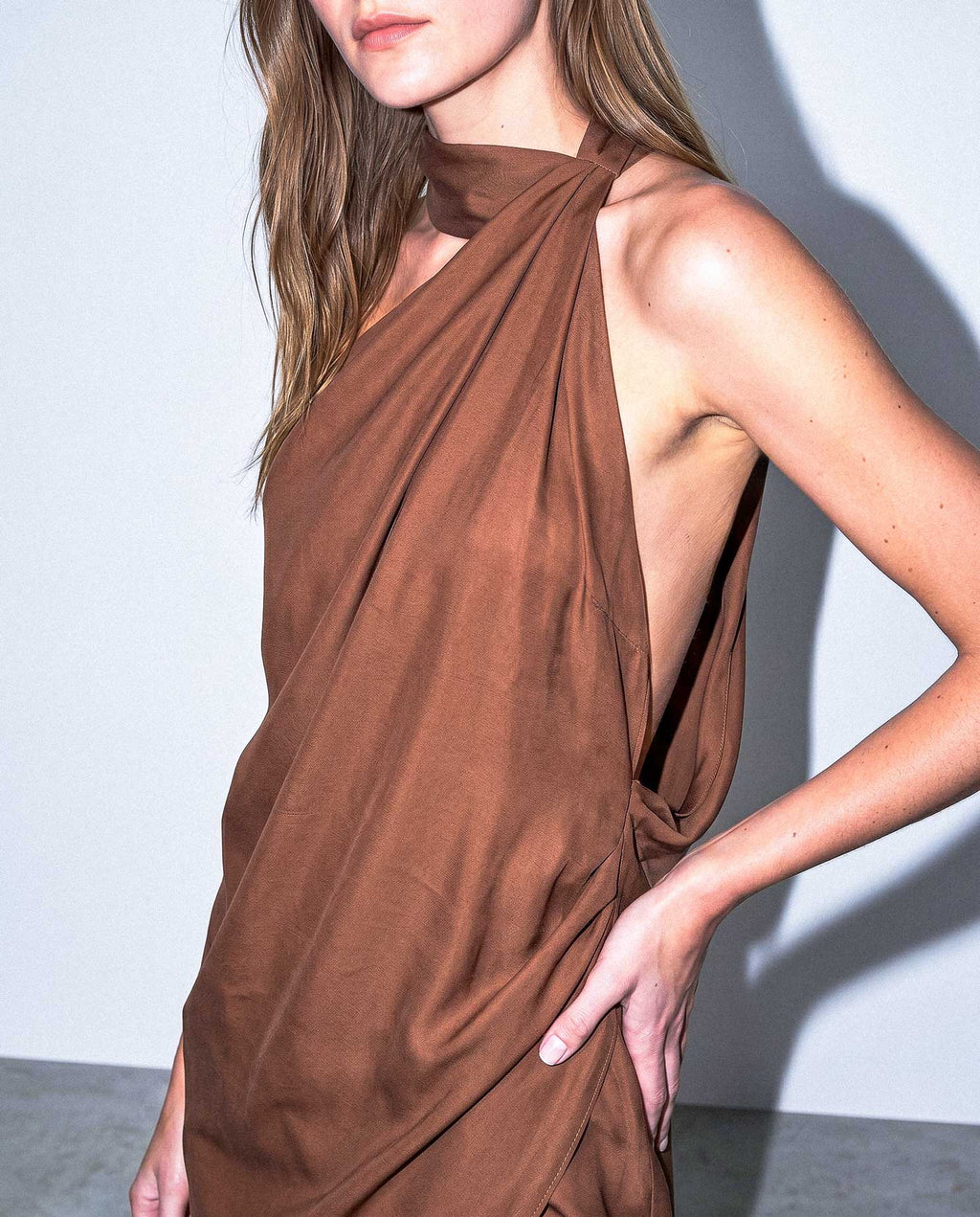Side view of ALMERA asymmetric open back mini dress in fluid cupro