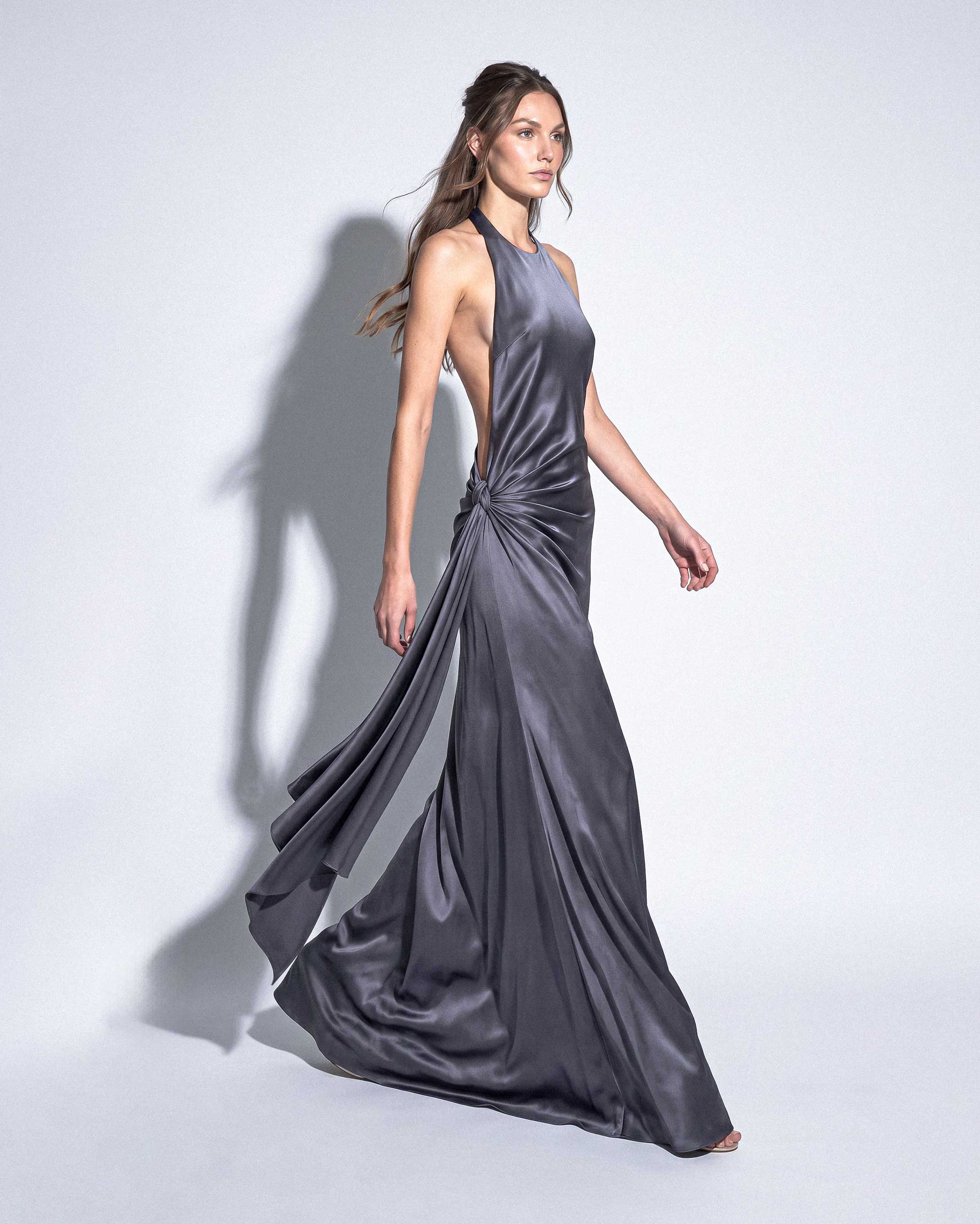 Side view of MIREILLE silk satin evening gown with open sides and flowing draped panel