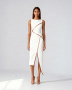Model wearing white asymmetrical midi dress with satin piping, featuring a sculpted silhouette and side slit.