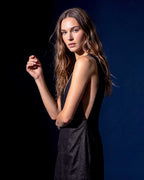 Side view of black sleeveless mini dress with deep V neckline