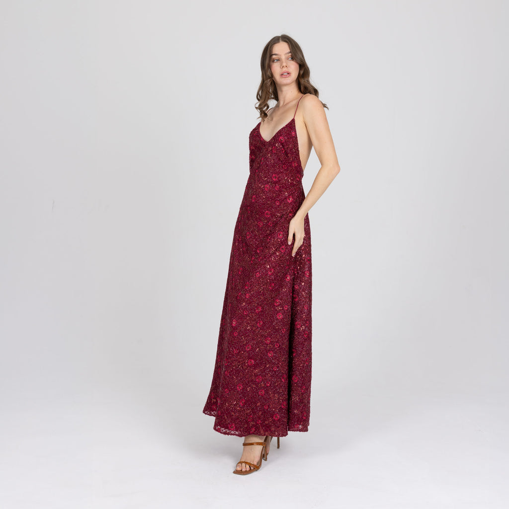 Side view of red embroidered gown with delicate satin straps and soft flared hem