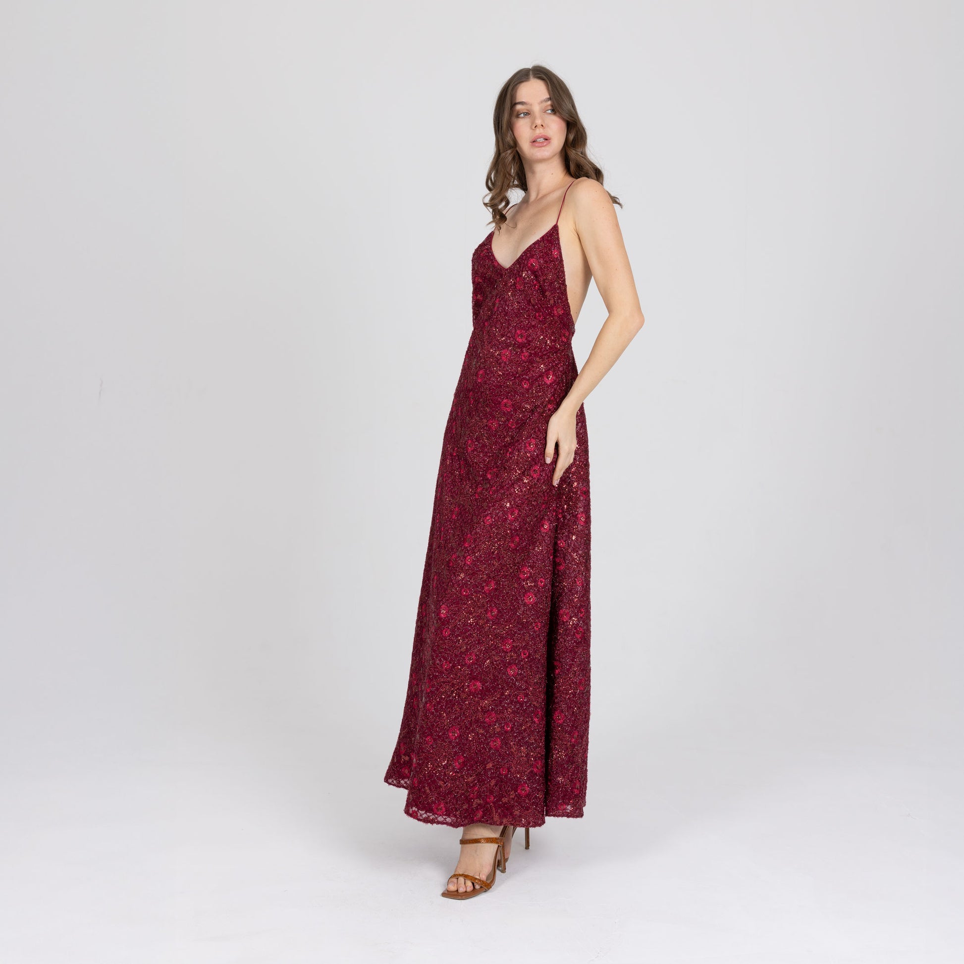 Side view of red embroidered gown with delicate satin straps and soft flared hem
