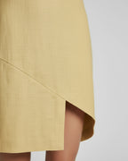 Asymmetrical hem detail on yellow linen mini dress