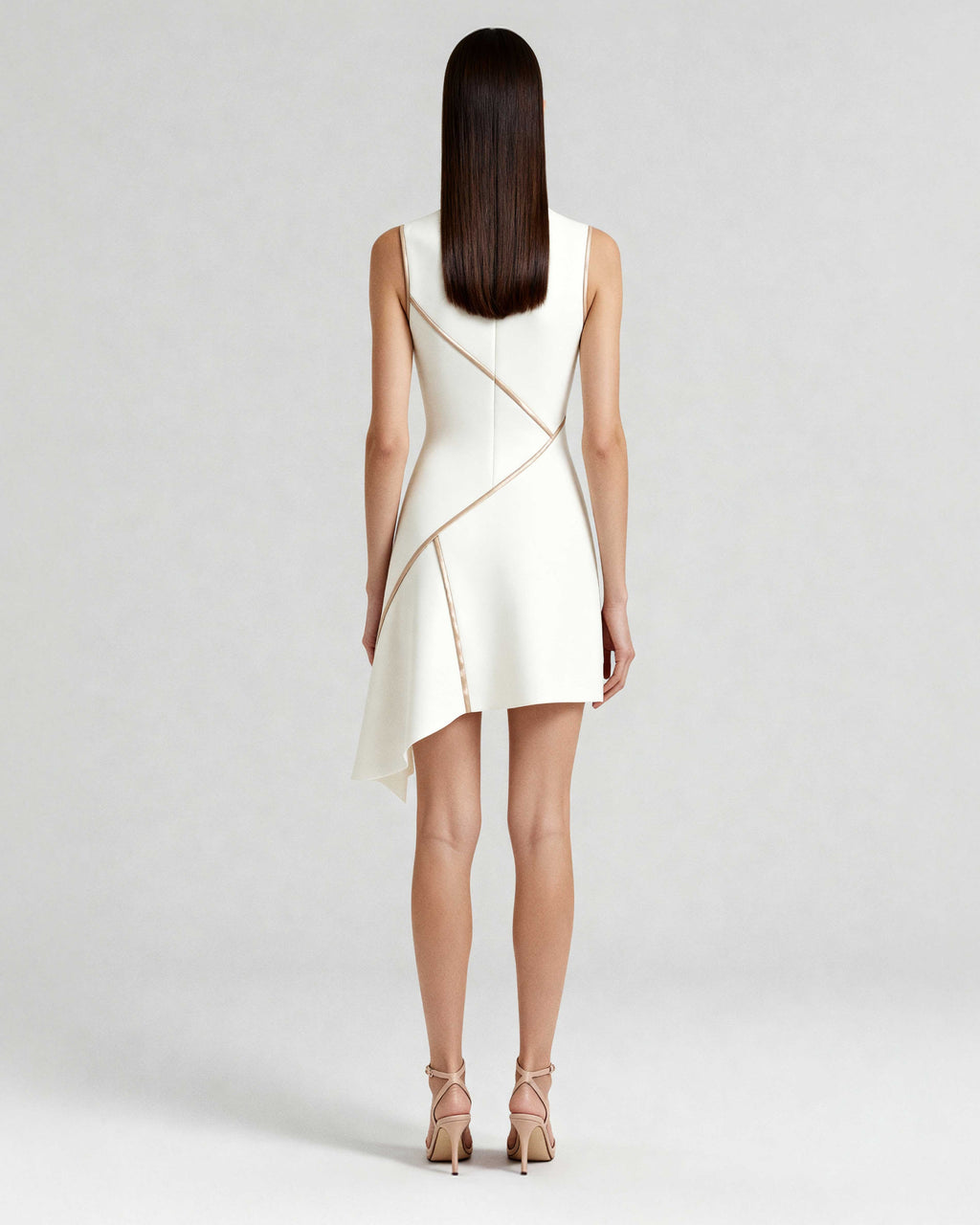 Model wearing sculpted mini dress with satin piping, ivory crepe finish