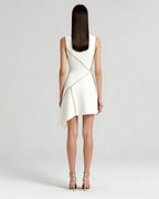 Model wearing sculpted mini dress with satin piping, ivory crepe finish