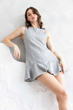 Model wearing A|LOUD pearl grey lace mini dress with flared hem, captured in a soft, minimal setting.