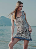 Model wearing Ayla Mini Dress by the sea – floral embroidered cocktail dress with satin and organza hem