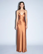 Full-length front view of the SEREA copper satin slip dress with bias-cut silhouette and deep V neckline.
